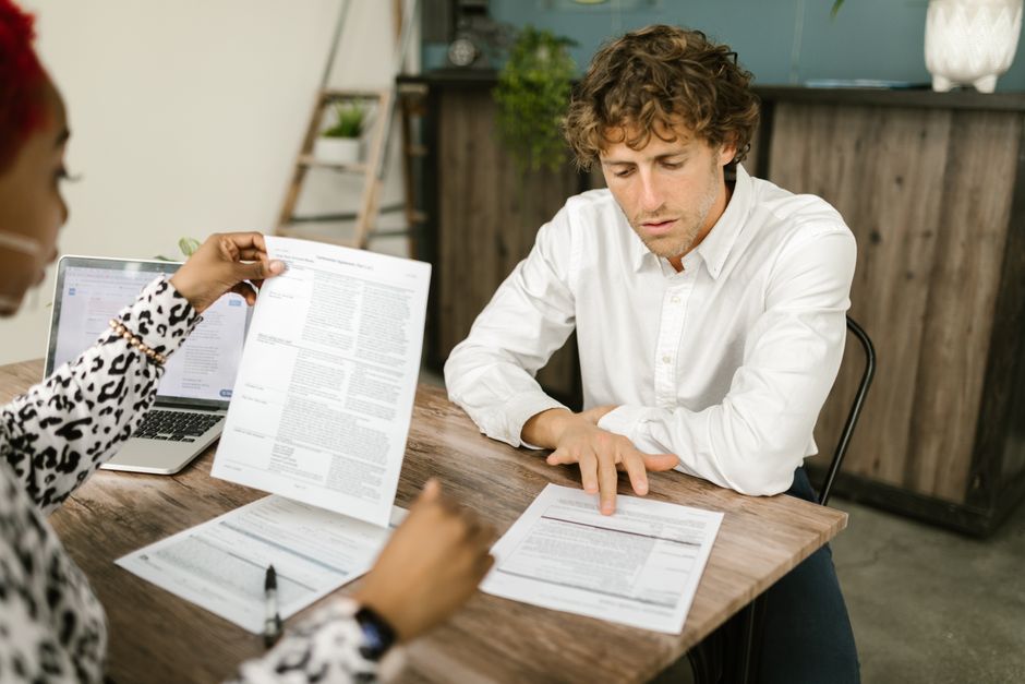 A CPA reviewing documents with a small-business owner at a desk